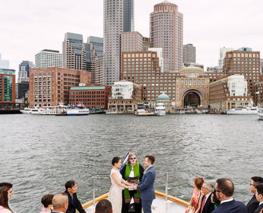 Bride and groom getting married on a boat in the harbor