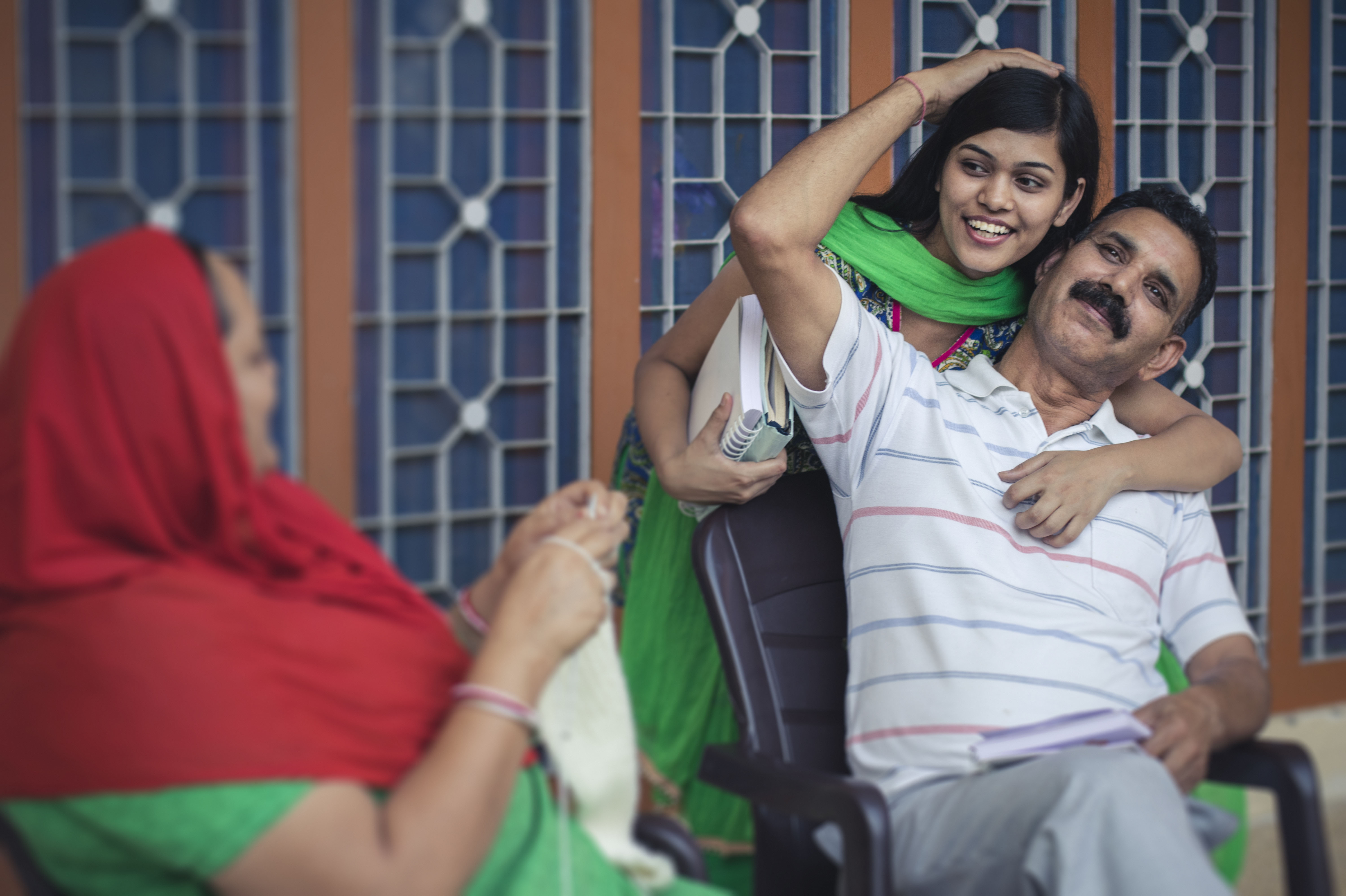 Father and daughter embrace one another before the daughter leaves for college.