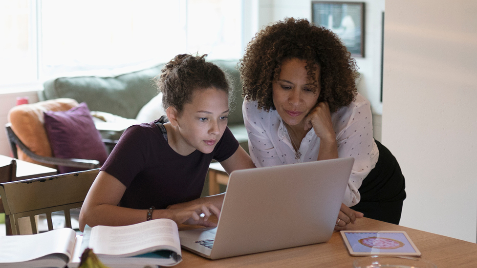 Mother and daughter looking at laptop