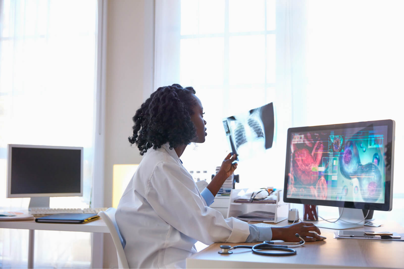 Doctor looks over X-rays in her office.