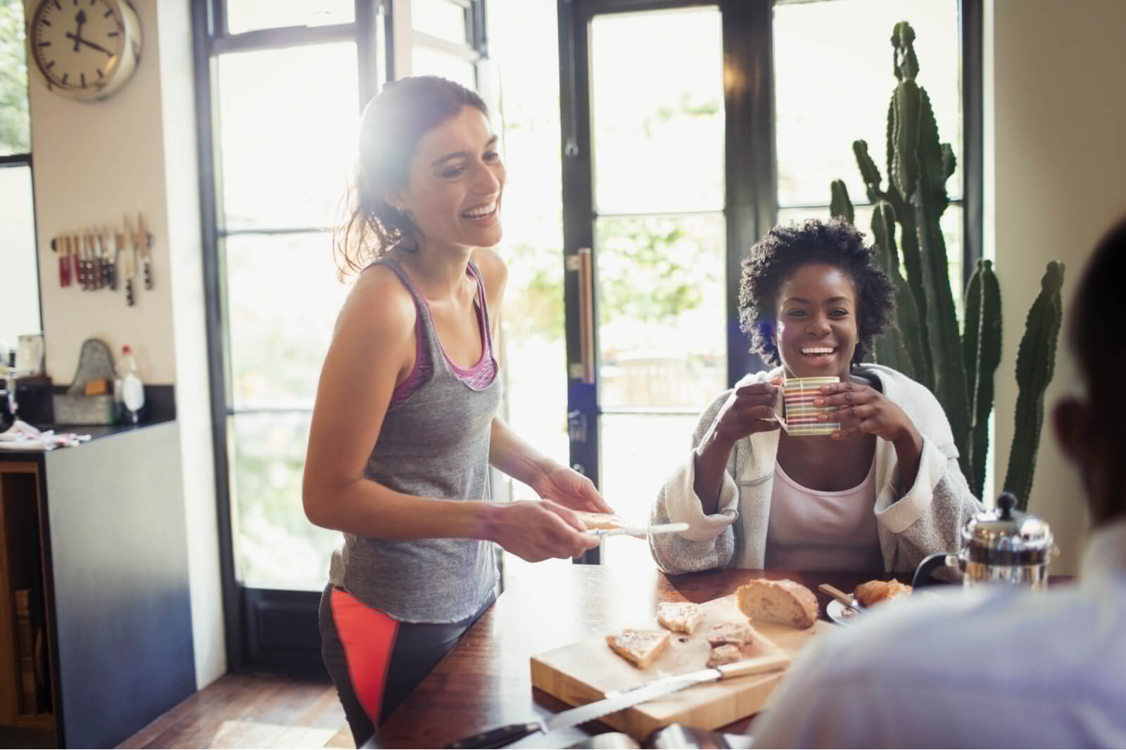 Friends chat over breakfast in a house.