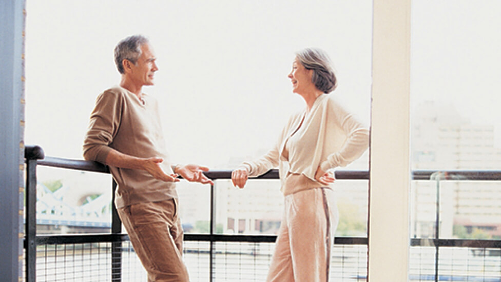 Older couple chatting on a balcony