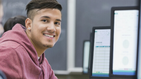 Smiling male college student at a computer