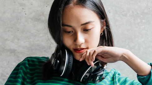 Woman reading with headphones on