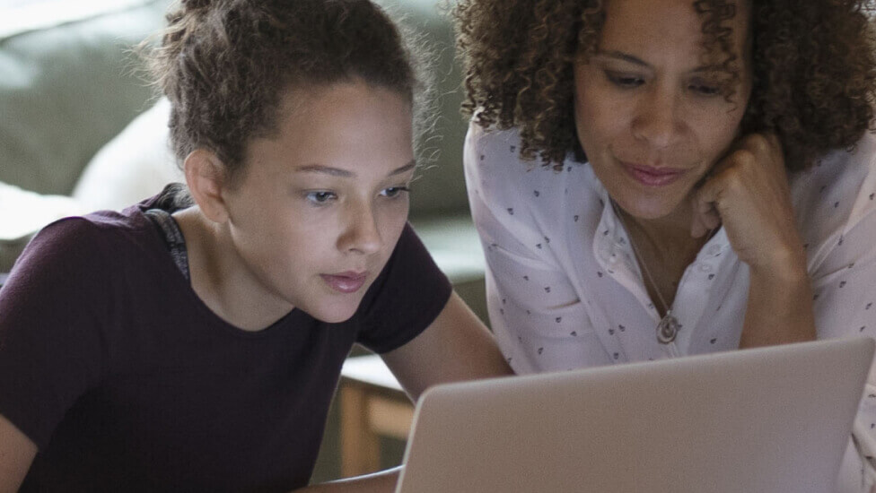 Mother and daughter looking at laptop