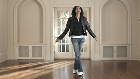 A woman standing in an unfurnished room