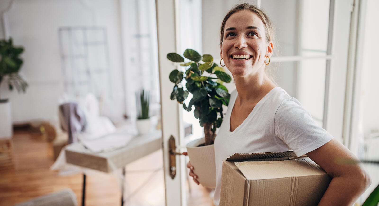A woman smiling while moving into her new home.