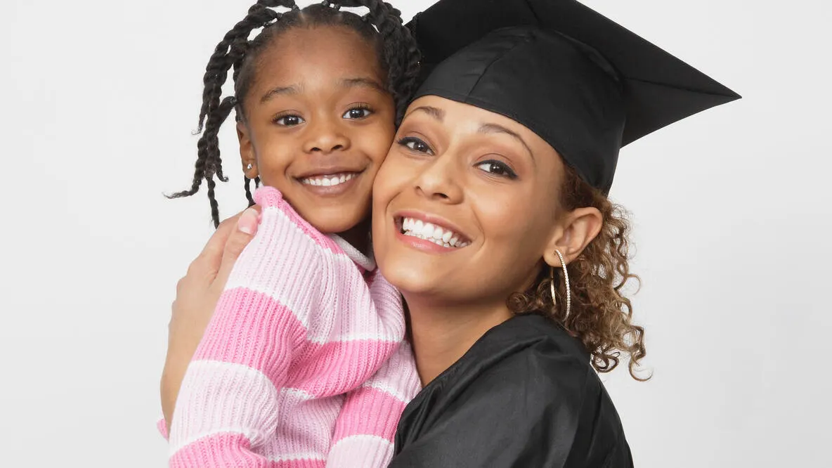 African-American graduate holding her young daughter
