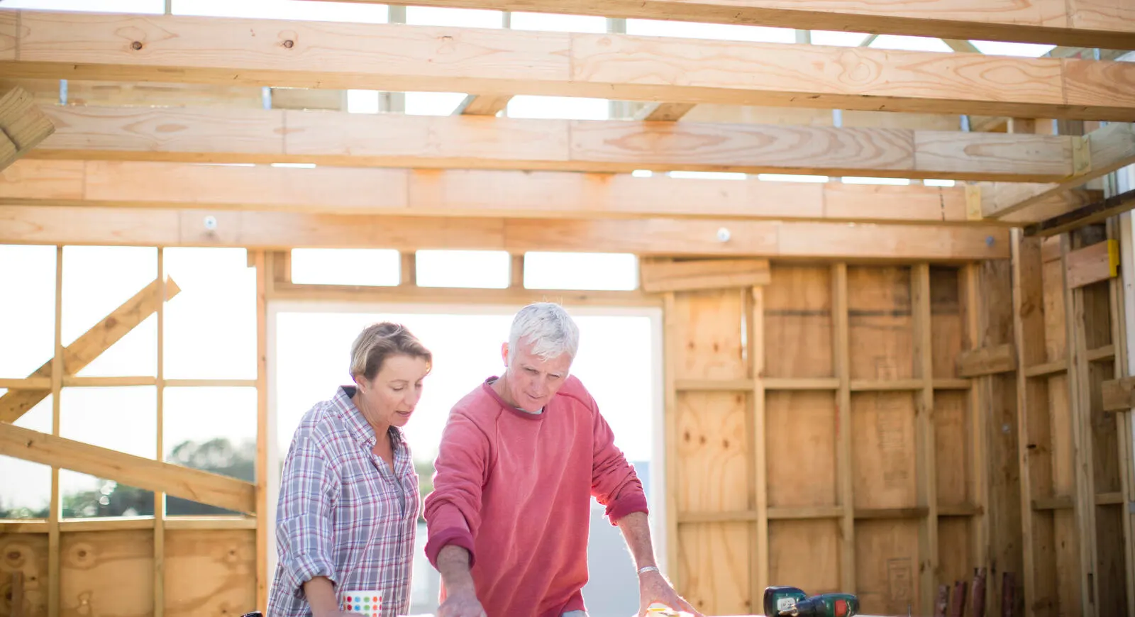 An elderly couple building a house