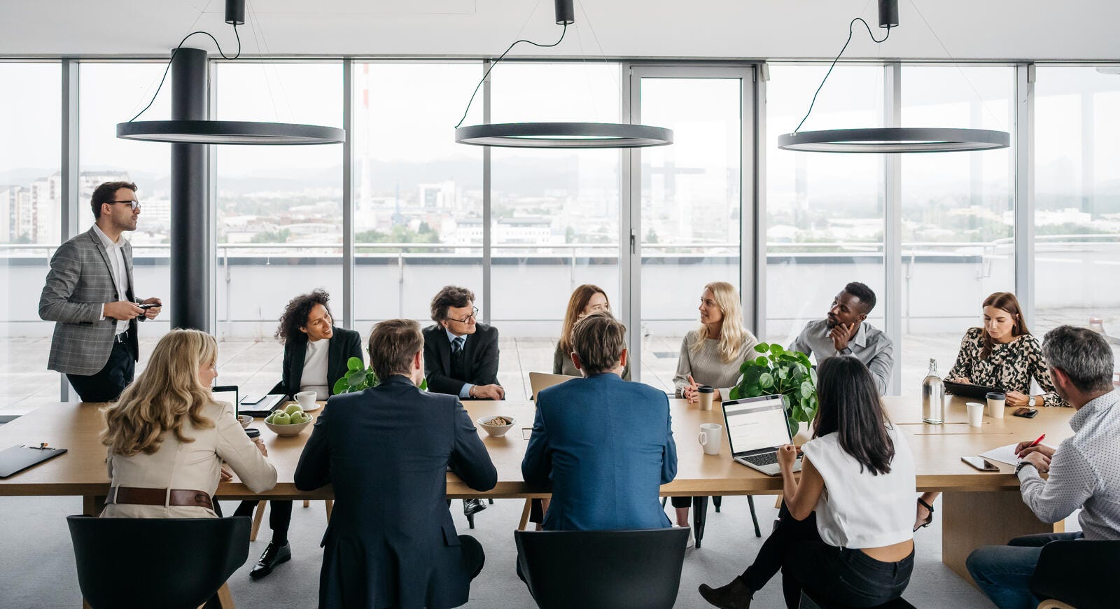 Large group of business people in a conference room overlooking a city.
