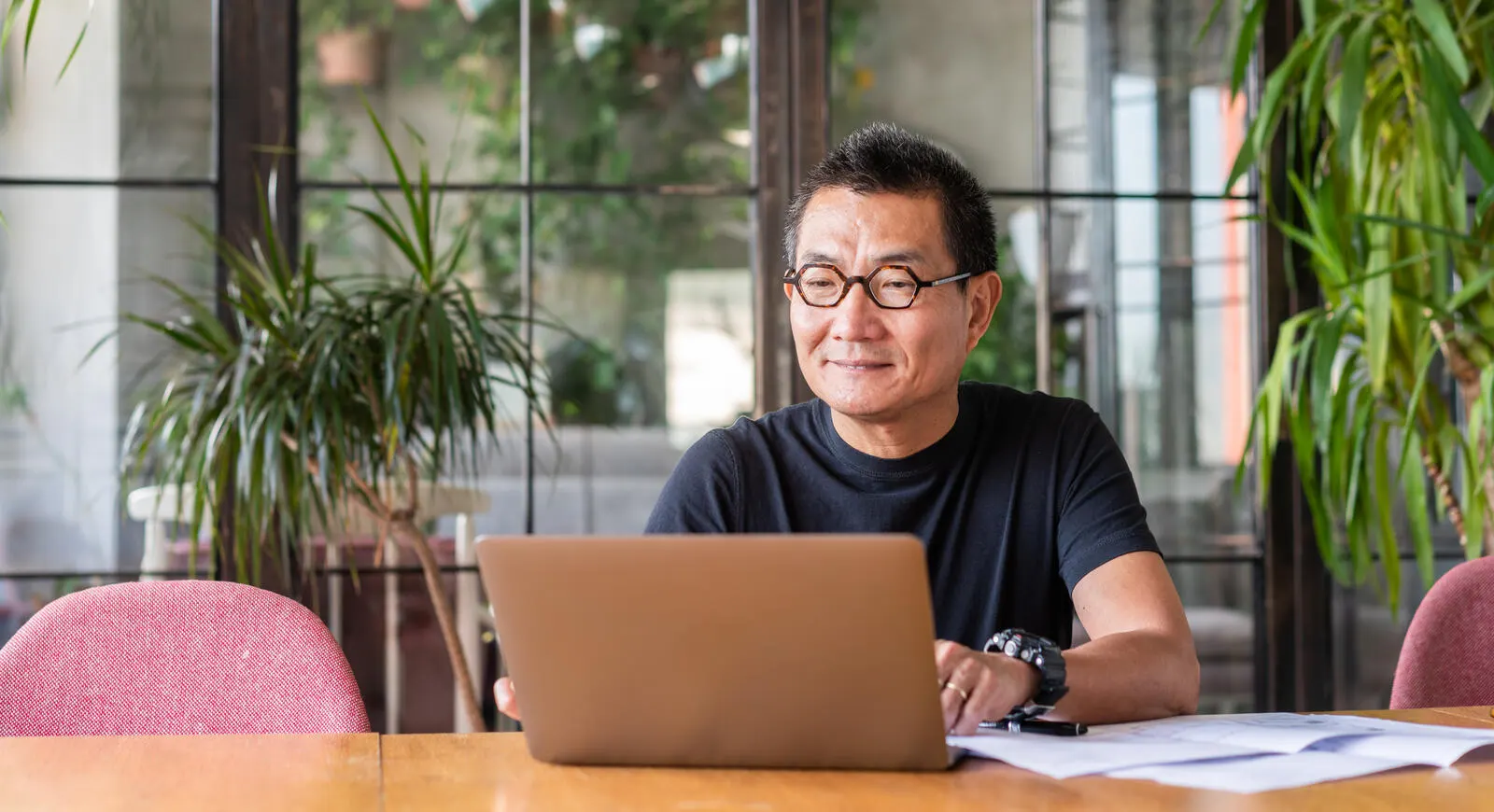 A man sitting at a desk and working on a laptop