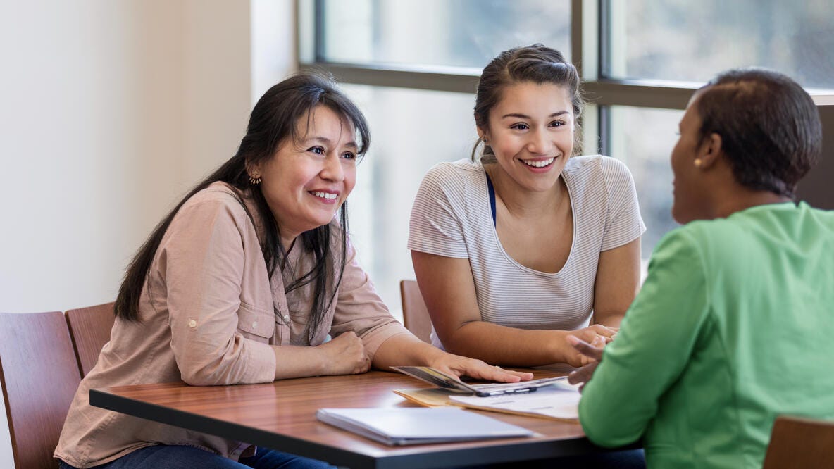 A mom and her daughter talk with an advisor about college savings plans.