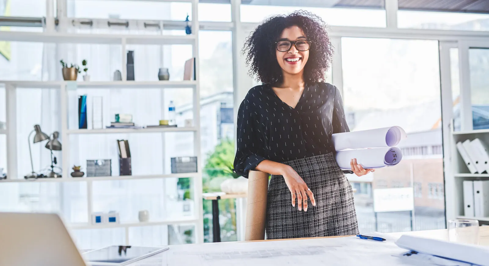 Woman working with blueprints in an office