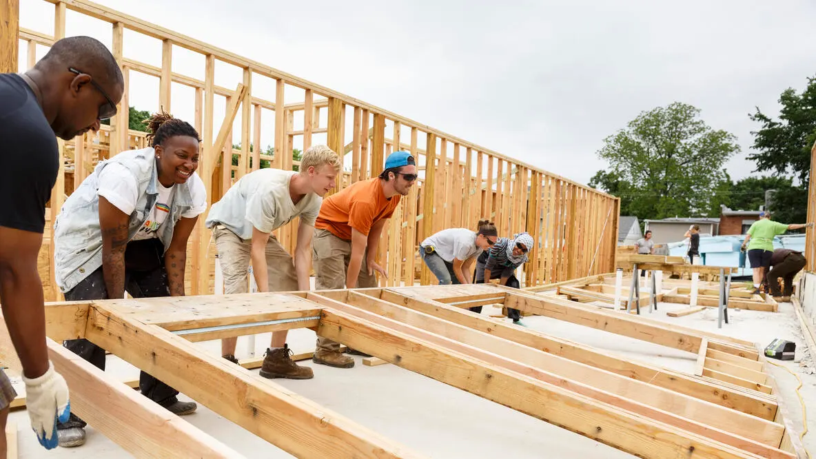 A group of people raising a house