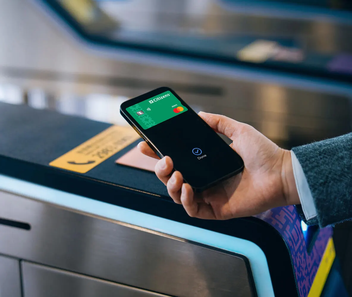 Close-up shot of hand paying for subway ticket at ticket gate, making a quick and easy contactless payment with smartphone.