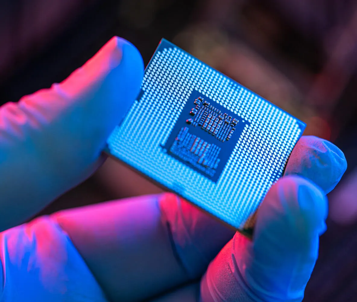 A hand holding a computer chip