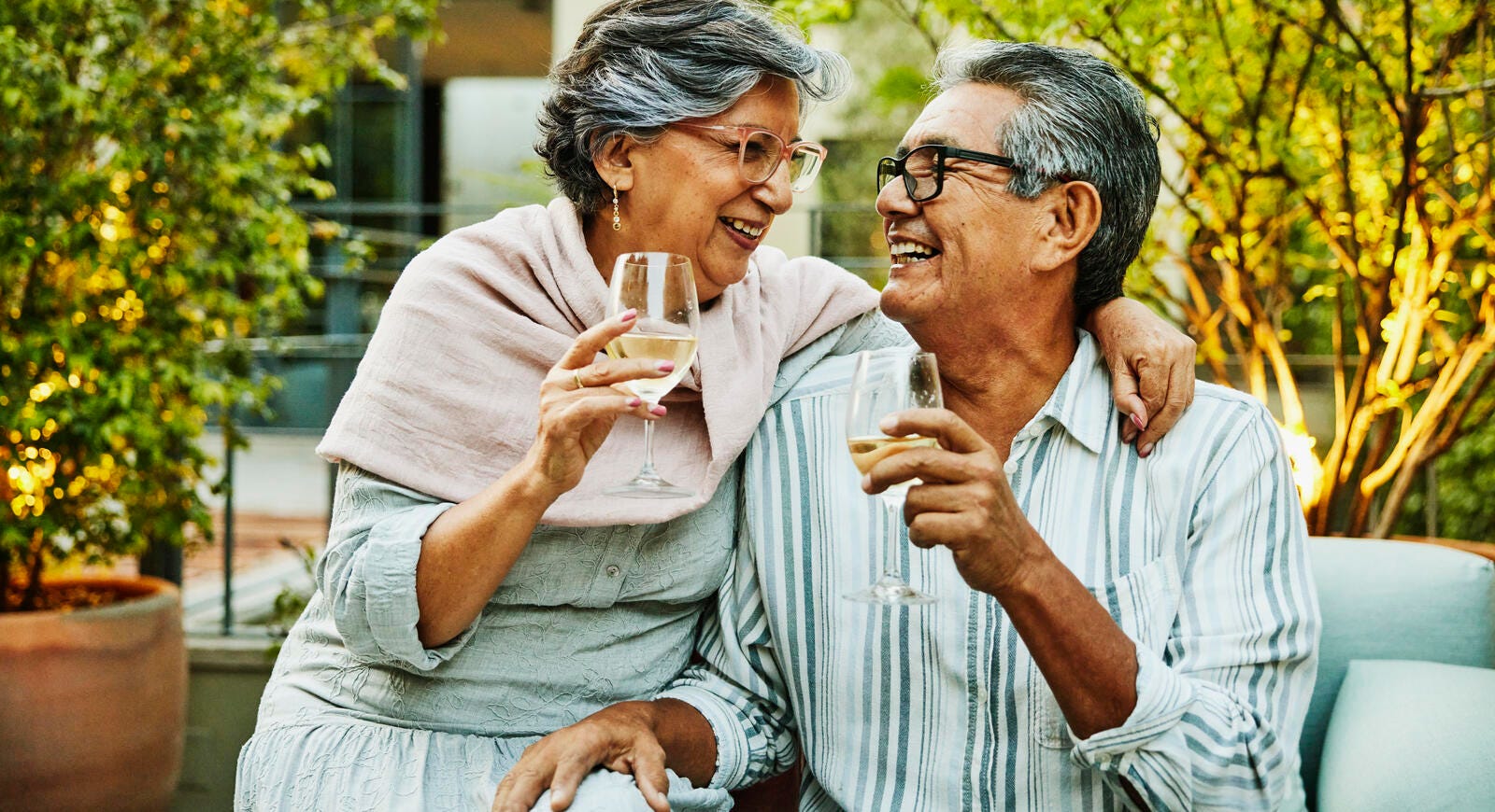 Pareja de adultos mayores abrazados tomando una copa.