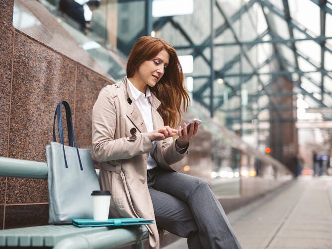 woman on phone on bench