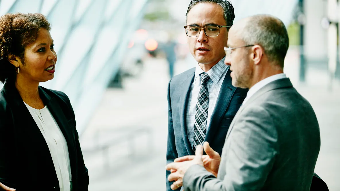 Three people in suits talking to each other