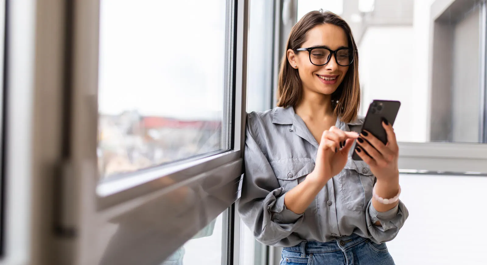 A woman smiling while using her phone