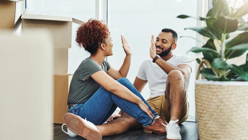 Two people sitting down and high-fiving