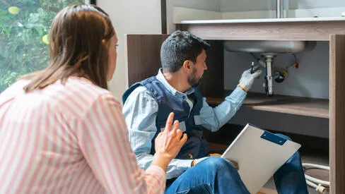 Couple looking over blueprint planning home renovations