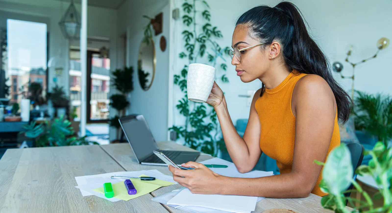 woman using laptop and cellphone
