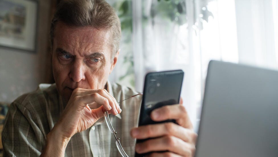 man looking seriously at smartphone