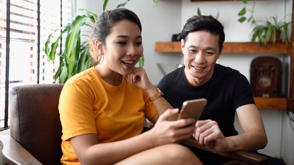 couple reading from a smart phone together at home