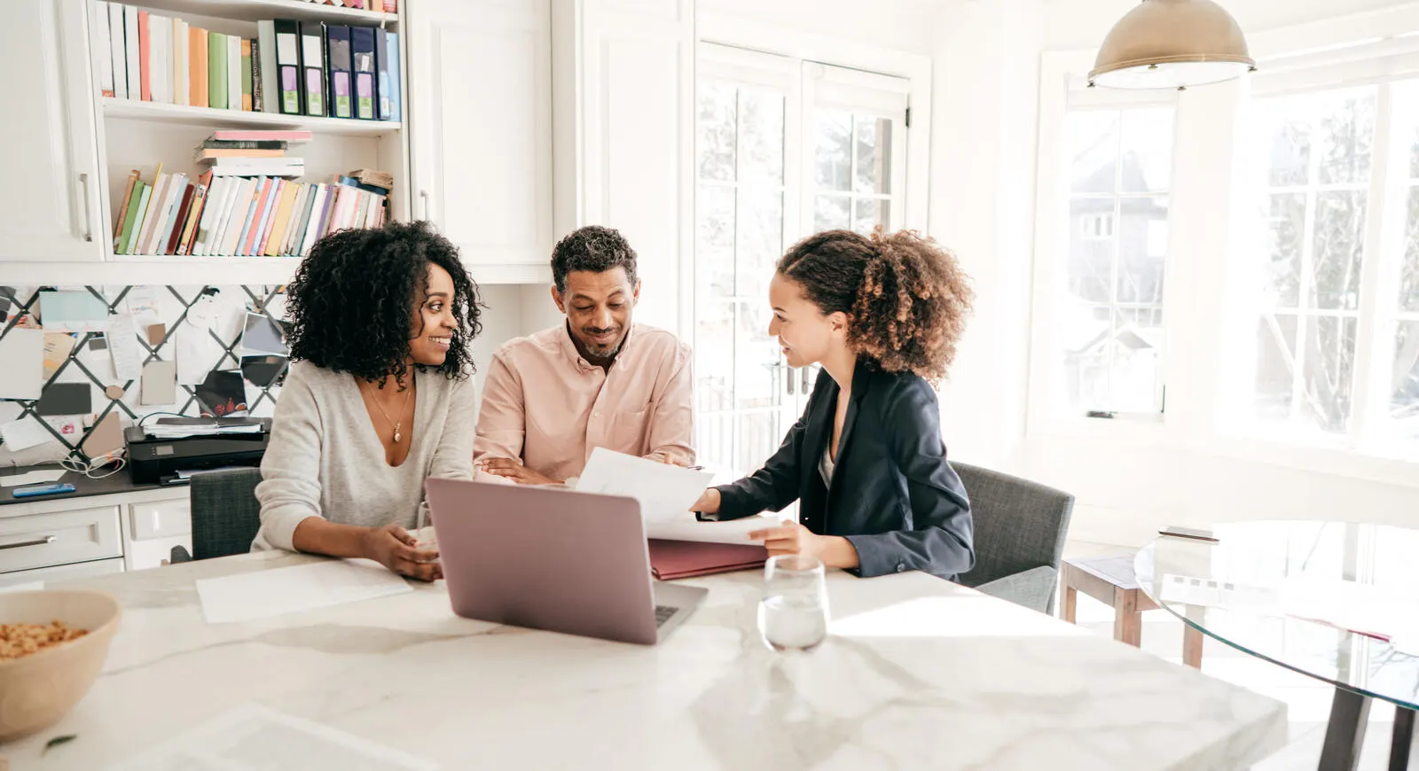 Three people looking over building plans