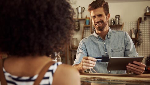 Man taking credit card payment at shop