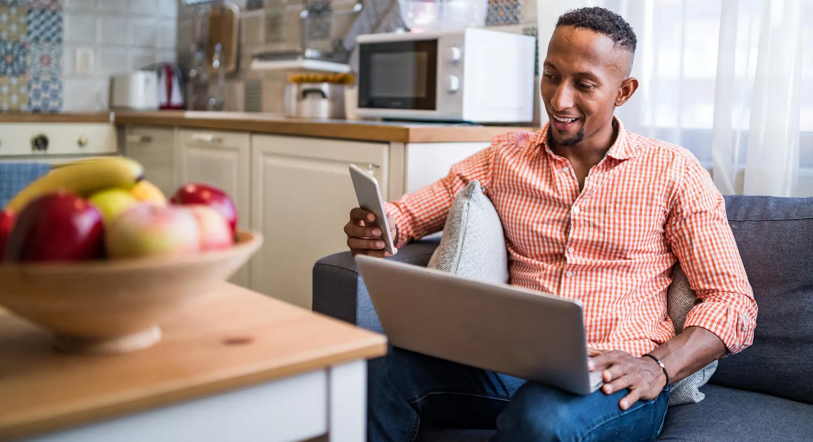 Adult male on a laptop and using phone