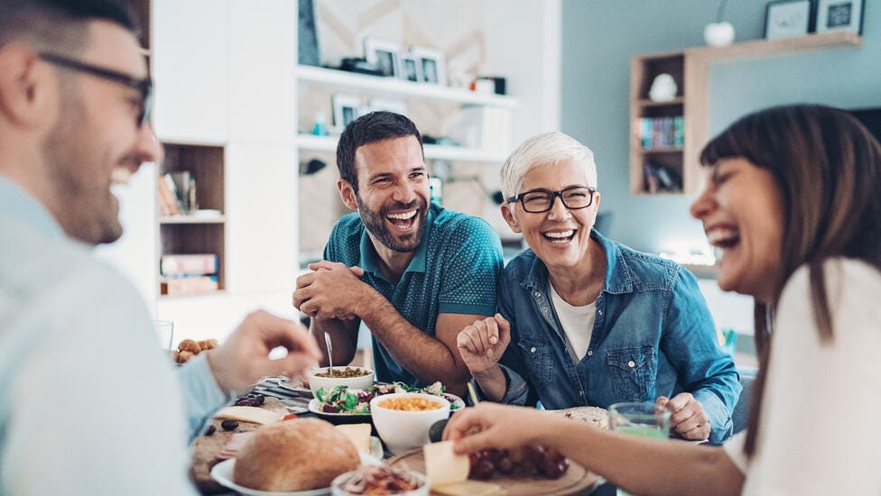 Family sitting together eating on table