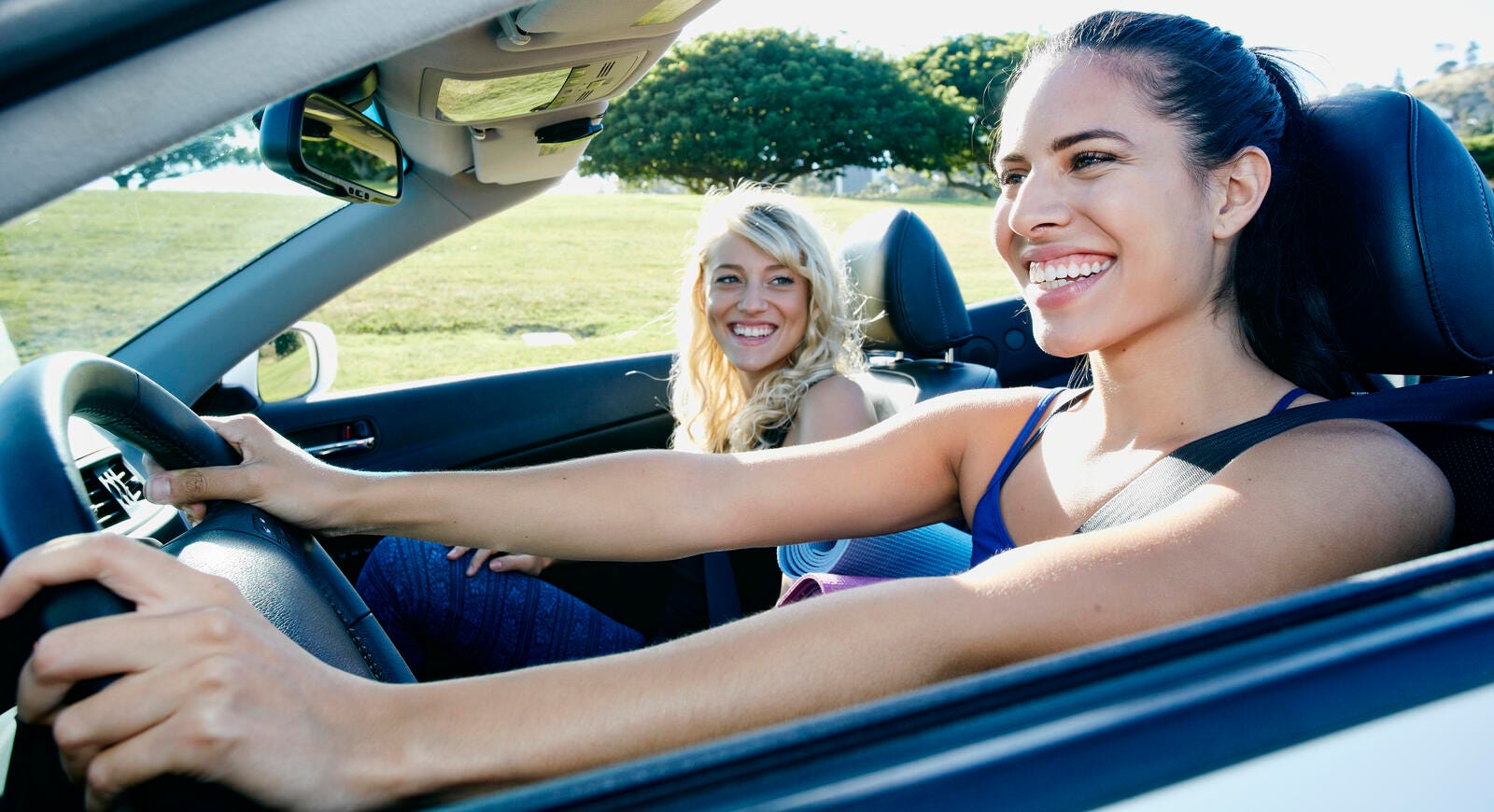Two women smiling in a car.