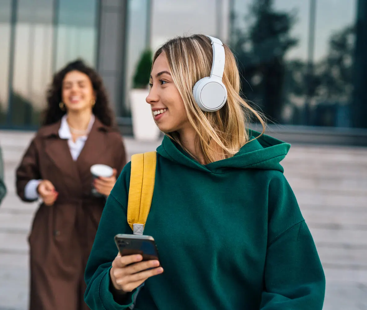 A student listening to music while walking to class.