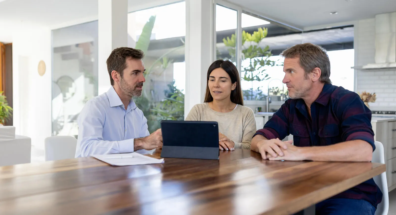 Three people discussing banking around a table