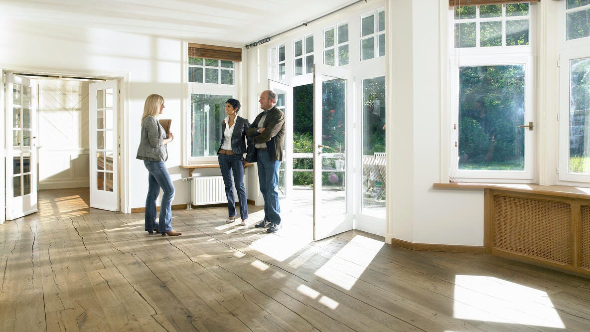 A real estate agent showing a couple a new home.