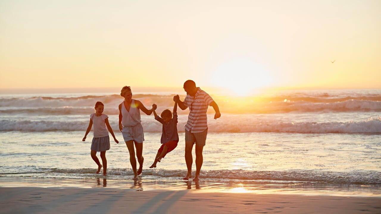 A family enjoying the beach at sunset.