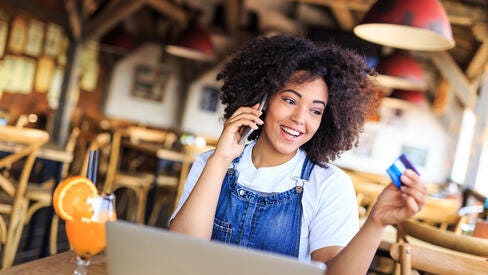 Woman talking on phone holding credit card