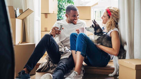 A couple sitting down with a husky