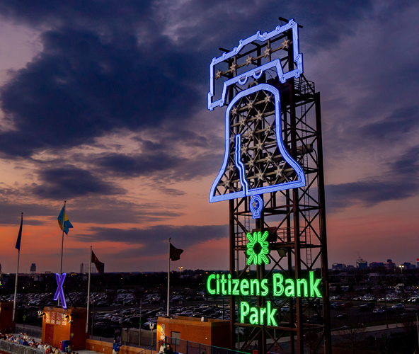 Citizens Bank Park Logo and Liberty Bell lit up at night.