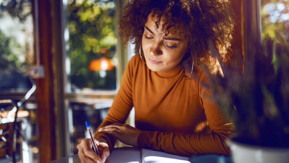 Joven adulta haciendo anotaciones en un cuaderno